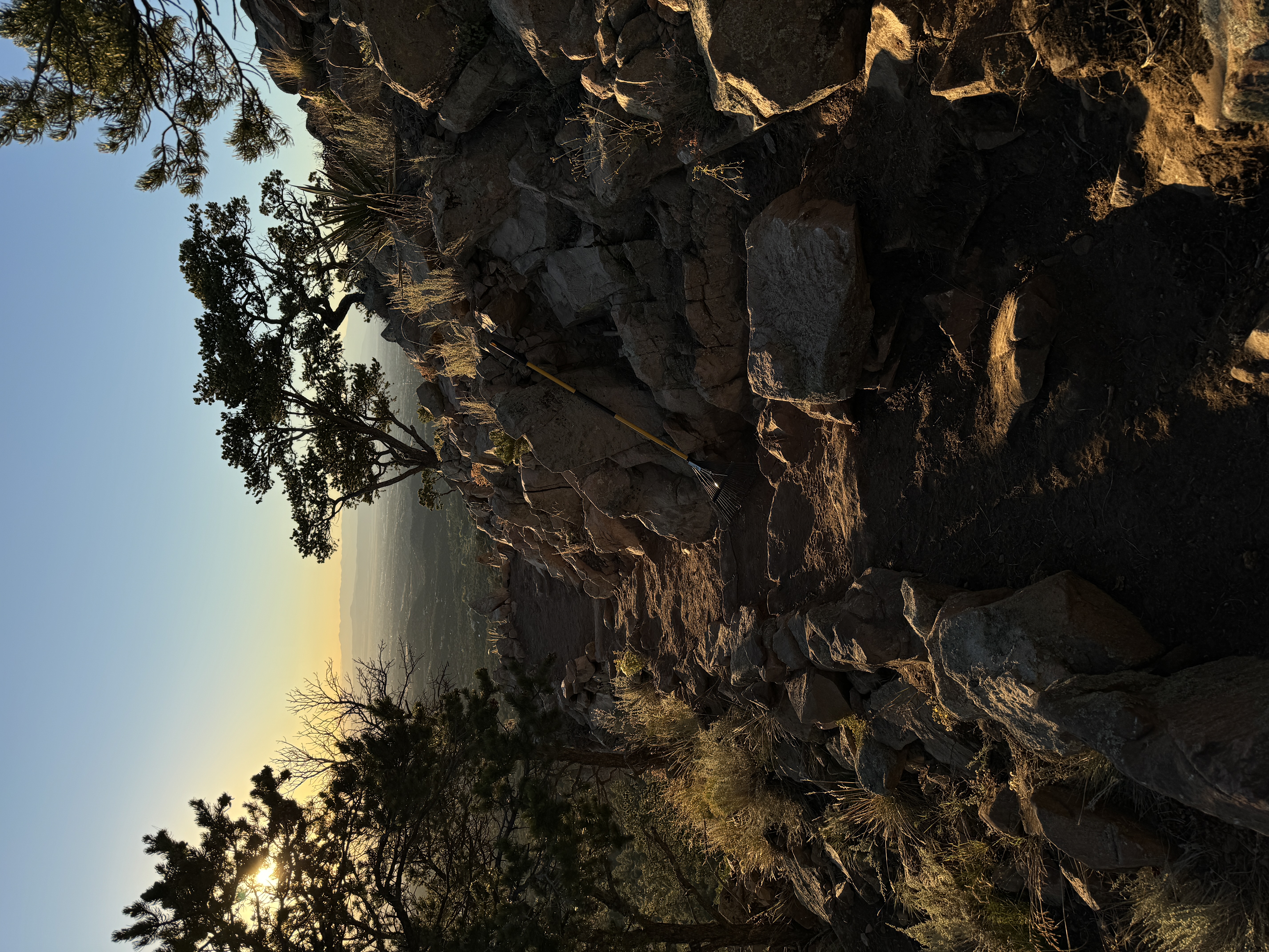 Stone wall at dusk — golden light on stacked stone, mountain ridge